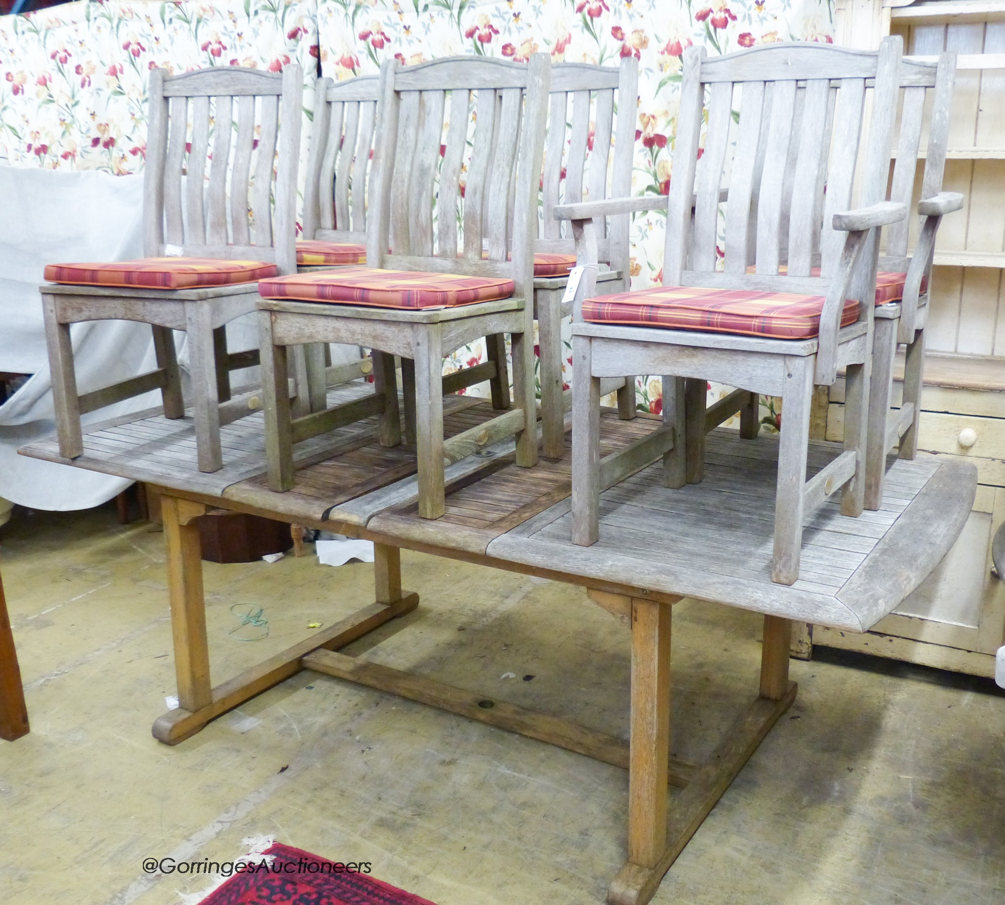 A weathered rectangular teak extending garden table, 220cm extended, width 110cm, height 74cm and six folding chairs, two with arms